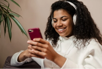 Mulher com fone de ouvido usando o telefone