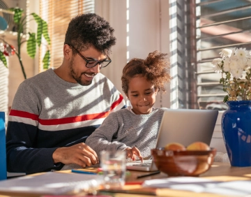 Pai e filha usando o computador juntos